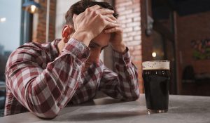 Depressed man drinking alone at beer pub